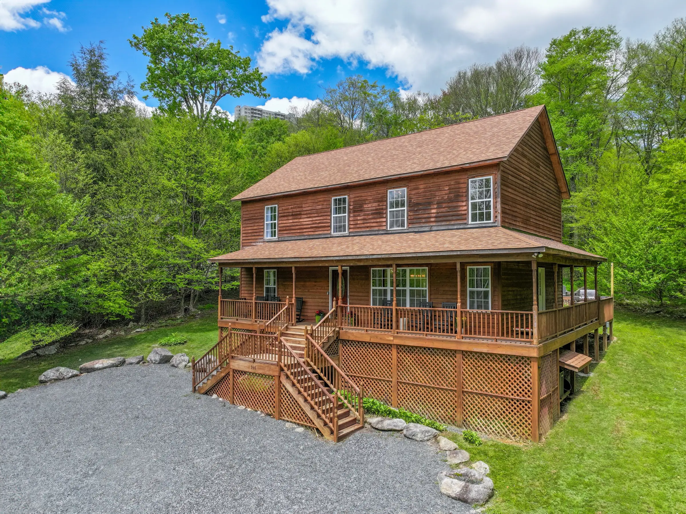 Gravel parking area and front approach to a two-story wood cabin