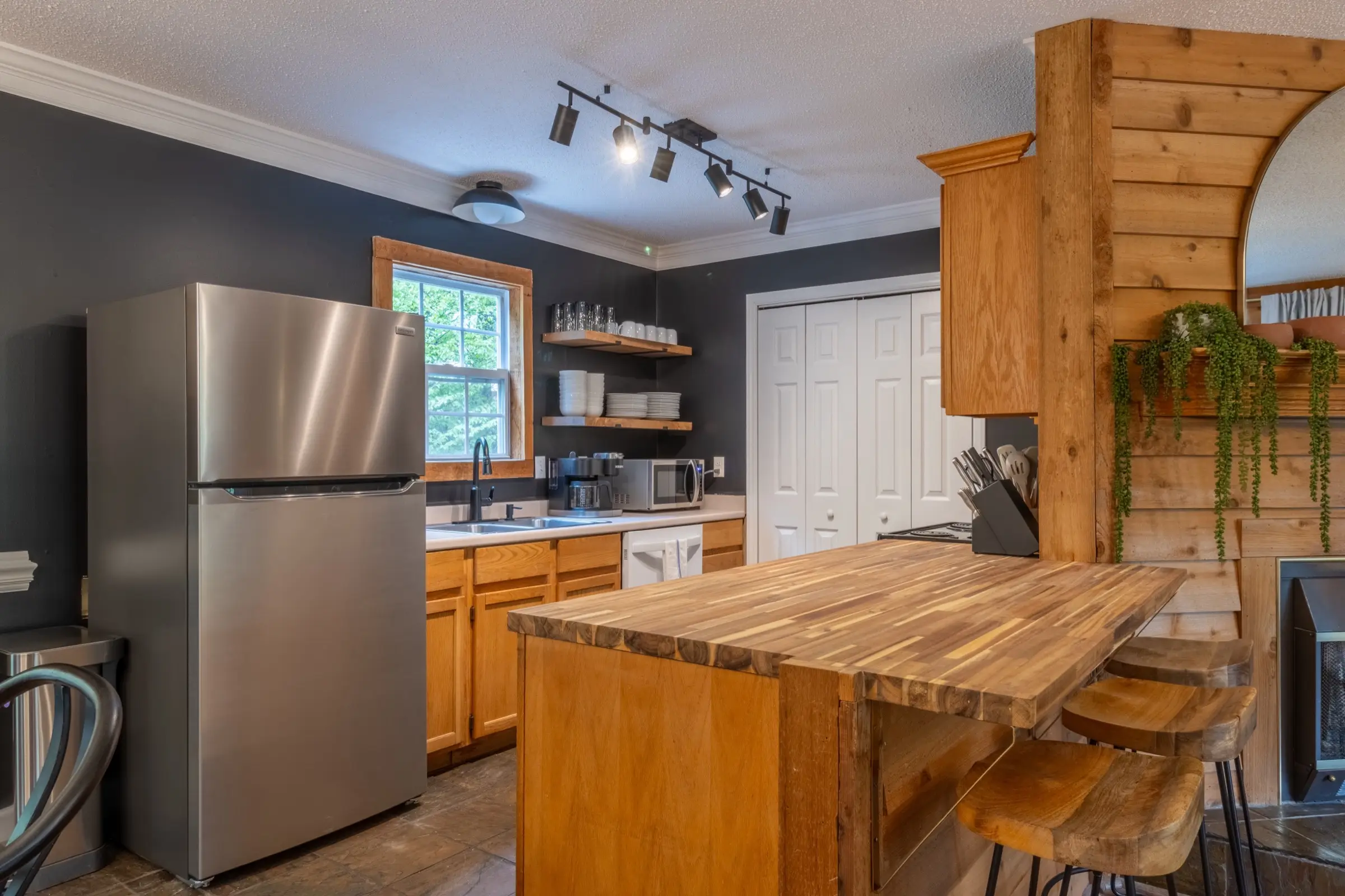 The kitchen from the side, with full-height cabinets, the range and the counter running through to the dining area.
