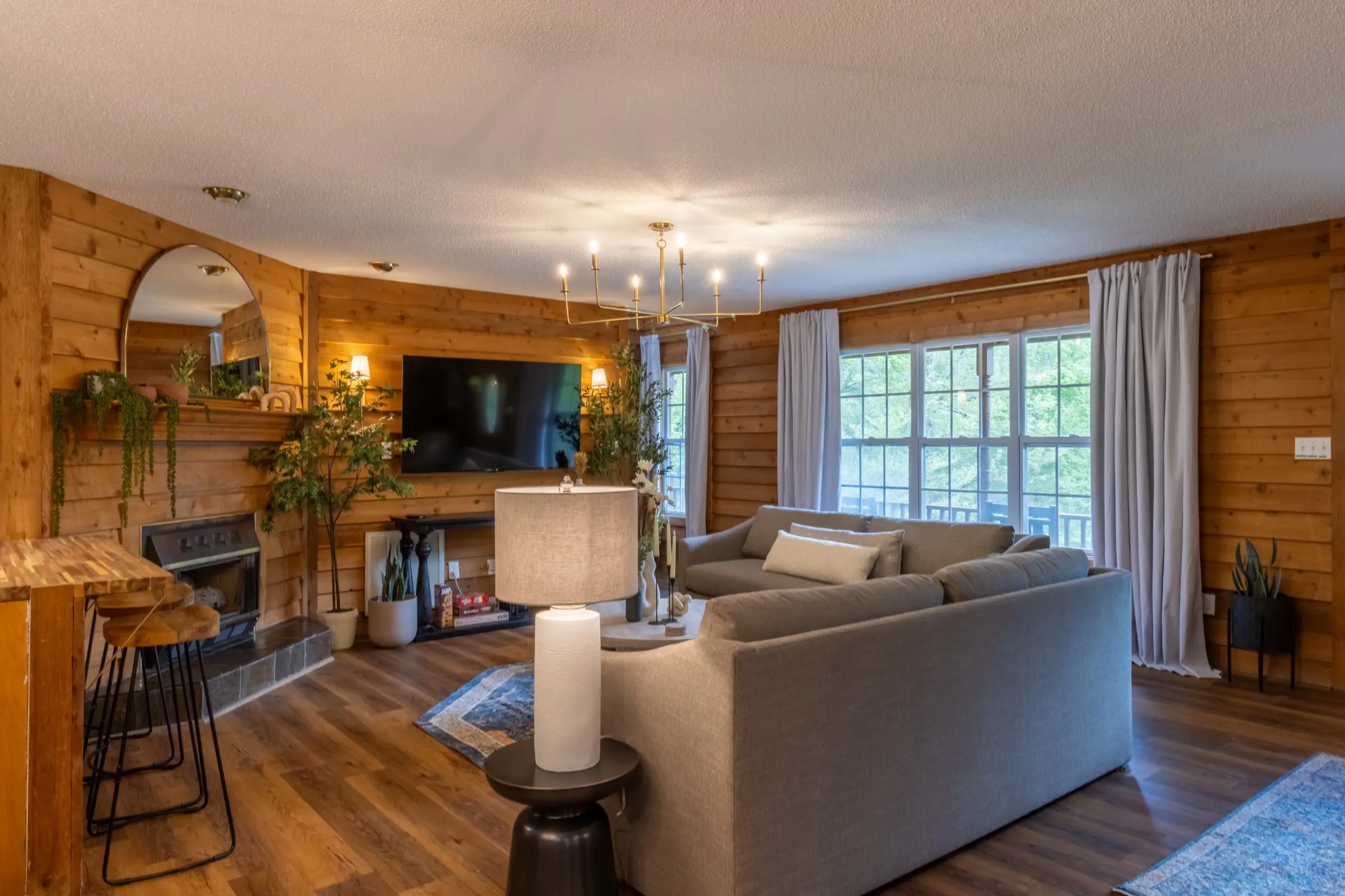 The living room sectional and round coffee table facing the television.