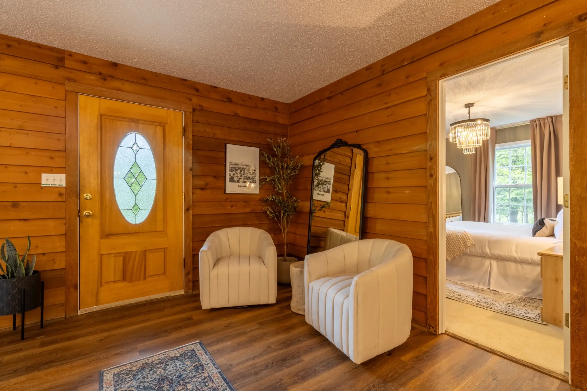 A sitting area near the stained-glass front door, with two armchairs and a leaning mirror.
