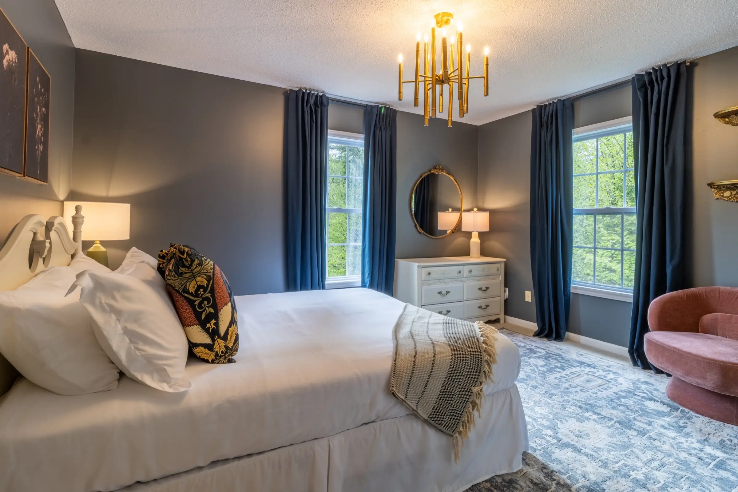 Upstairs bedroom 2, with a queen bed and a wall-mounted television above a wooden dresser.